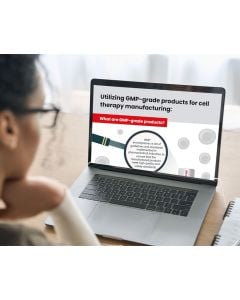 A woman looking at a laptop displaying an infographic titled 'Utilizing GMP-grade products for cell therapy manufacturing".