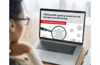 A woman looking at a laptop displaying an infographic titled 'Utilizing GMP-grade products for cell therapy manufacturing".